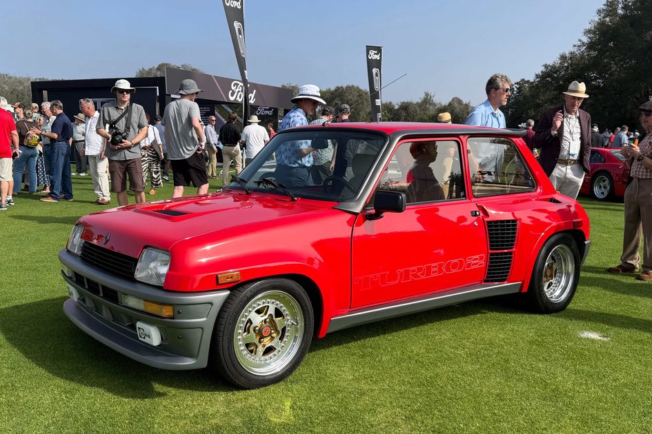 red 1985 renault 5 turbo on a green lawn at 2026 amelia concours